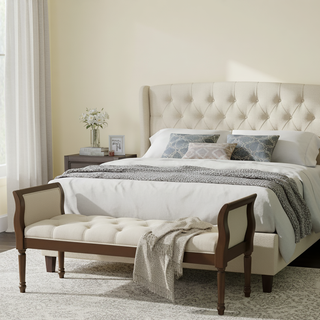 Tufted upholstered bench with curved arms and walnut frame