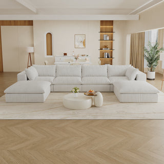 Modern living room with a large white sectional sofa, coffee table, and decorative elements.