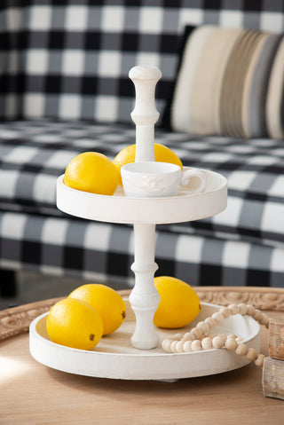 Add a touch of elegance to your home with this D11.8 x 15.4" Two-Tiered Round Wooden Tray in white. Perfect for organizing and displaying items, this versatile tray features two levels for efficient storage, making it ideal for use on coffee tables, countertops, or as a serving tray. The sleek white finish and wooden construction offer both durability and a modern aesthetic, seamlessly complementing various home decor styles. Use it to display decor, store essentials, or serve drinks and snacks at gathering